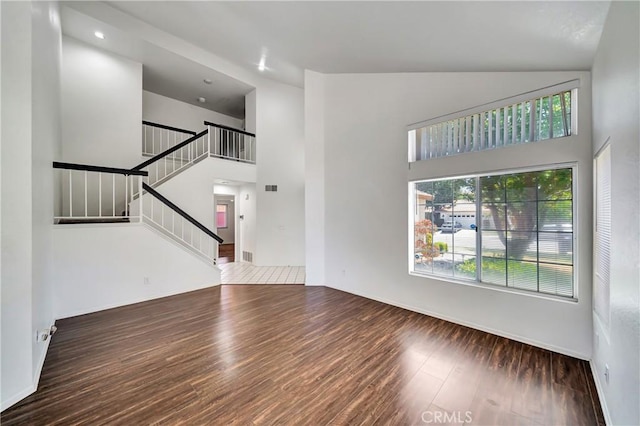 3115 Crowne Dr, Palmdale, CA 93551 - unfurnished living room featuring wood finished floors, high vaulted ceiling, and stairway