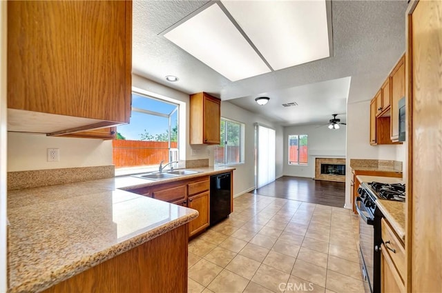 3115 Crowne Dr, Palmdale, CA 93551 - kitchen featuring black appliances, a ceiling fan, a fireplace, open floor plan, and light tile patterned floors