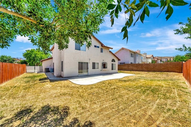 3115 Crowne Dr, Palmdale, CA 93551 - rear view of house featuring stucco siding, a patio, and a fenced backyard