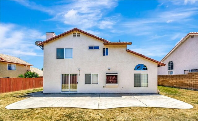 3115 Crowne Dr, Palmdale, CA 93551 - back of house with stucco siding, a fenced backyard, and a chimney