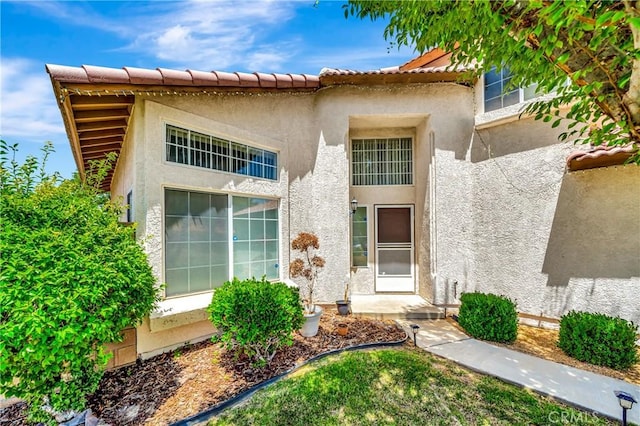 3115 Crowne Dr, Palmdale, CA 93551 - view of exterior entry featuring stucco siding and a tile roof