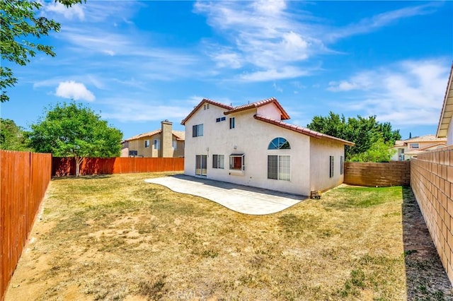 3115 Crowne Dr, Palmdale, CA 93551 - rear view of house featuring stucco siding, a patio, a fenced backyard, and a tiled roof