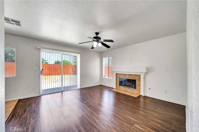 3115 Crowne Dr, Palmdale, CA 93551 - unfurnished living room with wood finished floors, ceiling fan, a tiled fireplace, and a textured ceiling