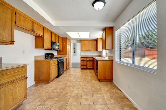 3115 Crowne Dr, Palmdale, CA 93551 - kitchen featuring black appliances, brown cabinets, light countertops, and light tile patterned flooring