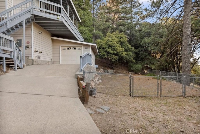 21658 W Buckthorne Dr, Cedarpines Park, CA 92322 - view of side of property with stairway, a gate, concrete driveway, and a garage