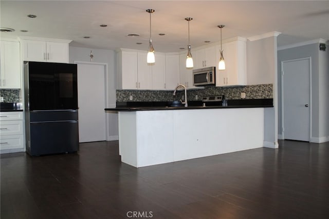 43340 Illinois, Palm Desert, CA 92211 - kitchen with freestanding refrigerator, stainless steel microwave, dark countertops, tasteful backsplash, and white cabinetry