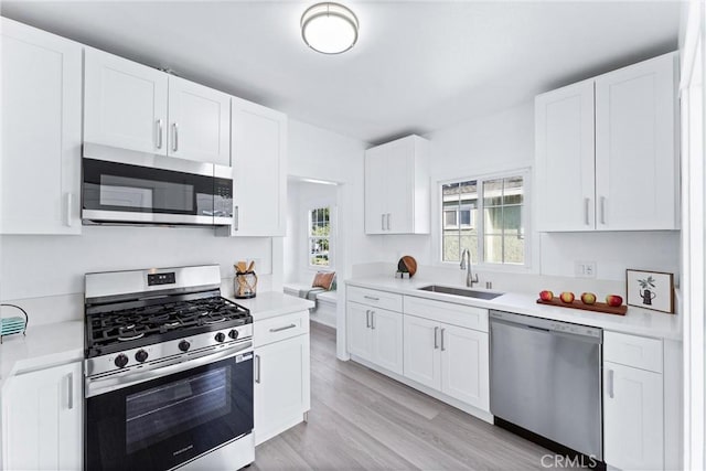 765 Loma Ave Unit 769, Long Beach, CA 90804 - kitchen featuring appliances with stainless steel finishes, light countertops, light wood-style flooring, and white cabinetry