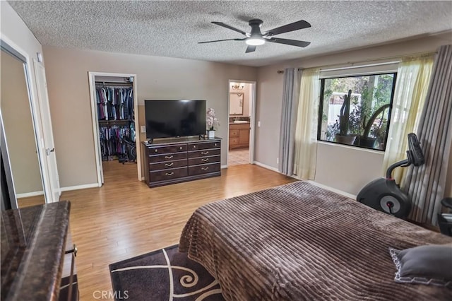 17149 Gledhill St, Northridge, CA 91325 - bedroom featuring a textured ceiling, a walk in closet, light wood finished floors, a closet, and a ceiling fan