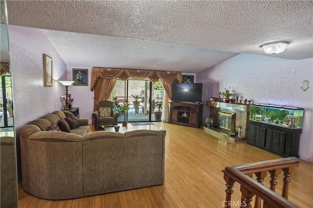 17149 Gledhill St, Northridge, CA 91325 - living area with a glass covered fireplace, a textured ceiling, wood finished floors, and lofted ceiling