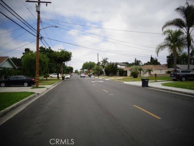 15728 Stevens Ave, Bellflower, CA 90706 - view of asphalt street with street lights, curbs, sidewalks, and a residential view
