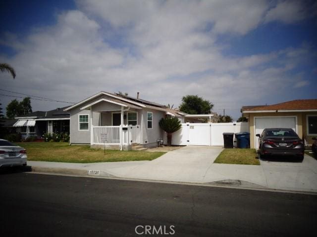 15728 Stevens Ave, Bellflower, CA 90706 - ranch-style home with a gate, concrete driveway, an attached garage, and solar panels