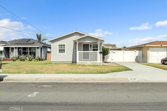15728 Stevens Ave, Bellflower, CA 90706 - view of front of house with a gate, stucco siding, roof mounted solar panels, and covered porch