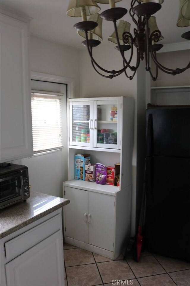 3641 W Oak Ave, Fullerton, CA 92833 - kitchen featuring freestanding refrigerator, light tile patterned flooring, white cabinetry, and light countertops