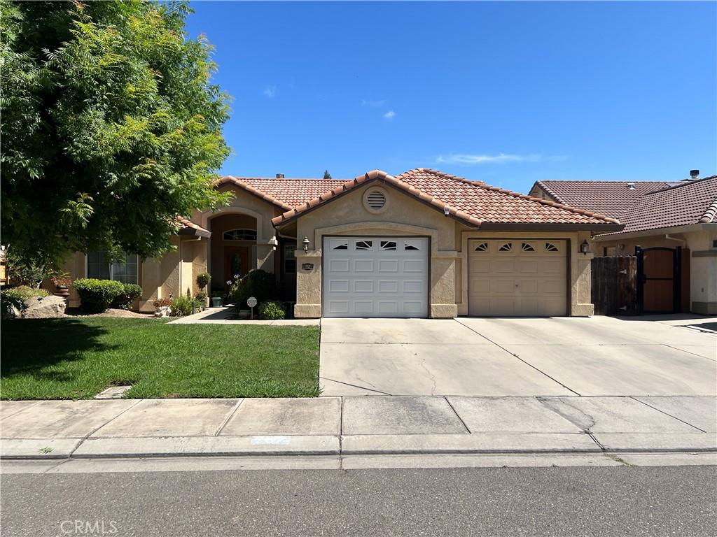 757 Nighthawk Ct, Merced, CA 95340 - mediterranean / spanish house featuring an attached garage, stucco siding, a tile roof, driveway, and a front yard