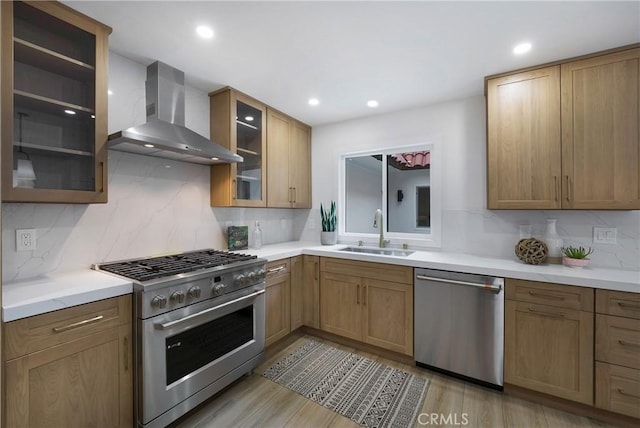 44 Seton Rd, Irvine, CA 92612 - kitchen with appliances with stainless steel finishes, wall chimney exhaust hood, tasteful backsplash, light countertops, and glass insert cabinets