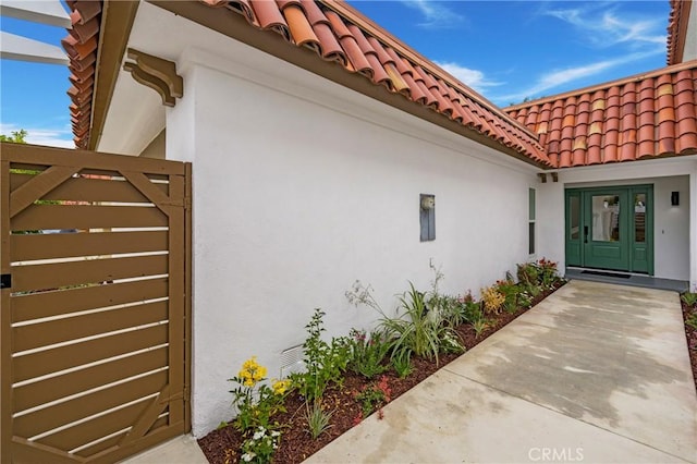 44 Seton Rd, Irvine, CA 92612 - view of exterior entry with a tile roof, stucco siding, and french doors