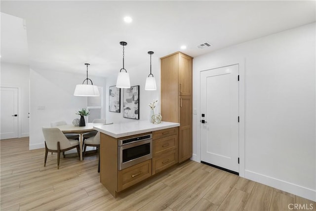 44 Seton Rd, Irvine, CA 92612 - kitchen featuring light wood-type flooring, a peninsula, stainless steel microwave, light countertops, and recessed lighting
