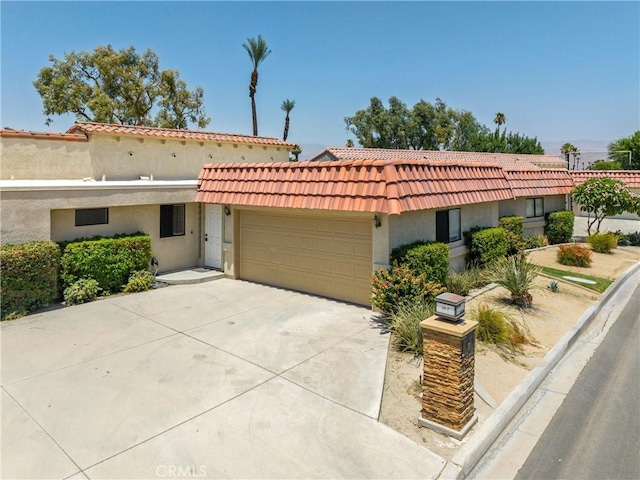 40316 Bay Hill Way, Palm Desert, CA 92211 - mediterranean / spanish house with an attached garage, stucco siding, a tiled roof, and concrete driveway