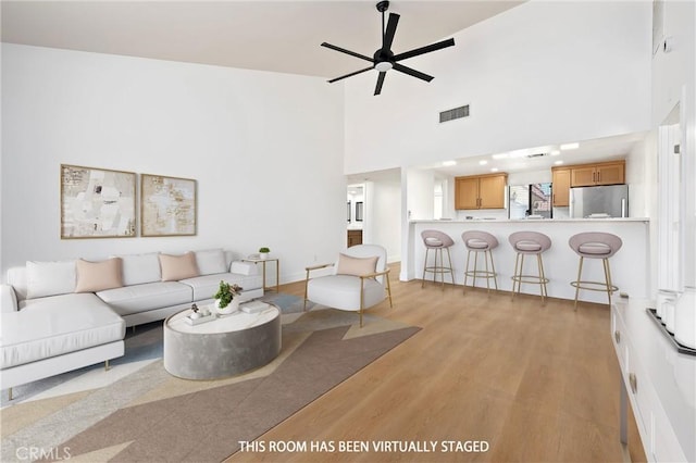 40316 Bay Hill Way, Palm Desert, CA 92211 - living room featuring light wood-style floors, a ceiling fan, and a towering ceiling