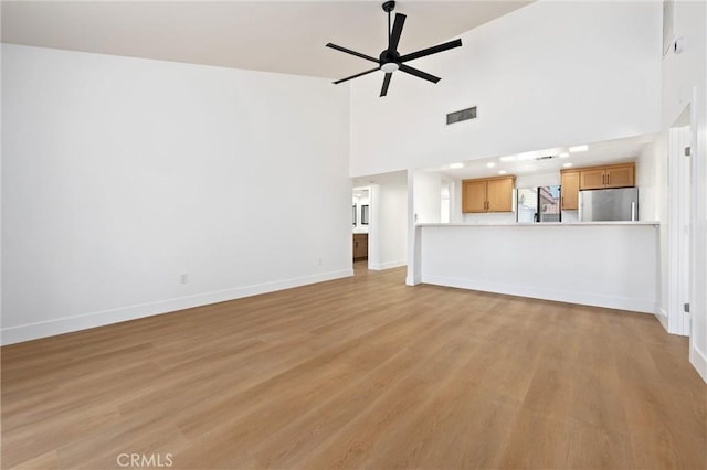 40316 Bay Hill Way, Palm Desert, CA 92211 - unfurnished living room featuring a ceiling fan, light wood finished floors, and a towering ceiling