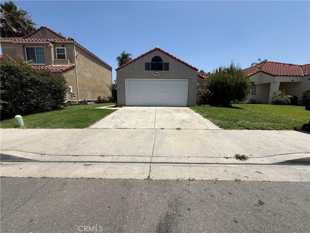 3567 Ganador Ct, Riverside, CA 92503 - view of front of house featuring a front yard, concrete driveway, stucco siding, and a tile roof