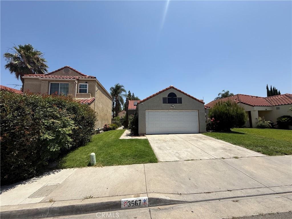 3567 Ganador Ct, Riverside, CA 92503 - mediterranean / spanish-style home with a front lawn, a tiled roof, stucco siding, and concrete driveway