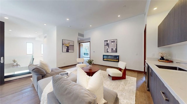 12480 Viewcrest Rd, Studio City, CA 91604 - living area featuring light wood finished floors, a glass covered fireplace, and recessed lighting