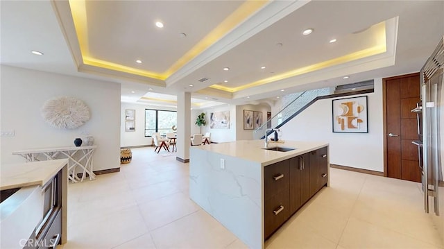 12480 Viewcrest Rd, Studio City, CA 91604 - kitchen with a tray ceiling, modern cabinets, a center island with sink, light stone countertops, and recessed lighting