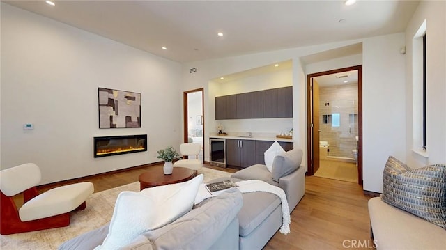 12480 Viewcrest Rd, Studio City, CA 91604 - living area with wine cooler, recessed lighting, light wood finished floors, and a glass covered fireplace