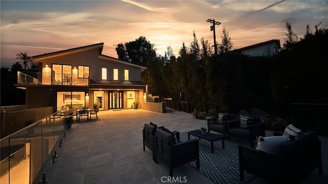 12480 Viewcrest Rd, Studio City, CA 91604 - back of house at dusk with an outdoor hangout area, a patio area, stucco siding, a balcony, and outdoor dining space