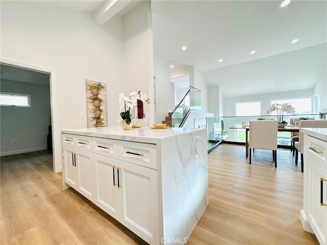83 Palm Beach Ct, Dana Point, CA 92629 - kitchen with vaulted ceiling, white cabinetry, light wood finished floors, light stone counters, and recessed lighting