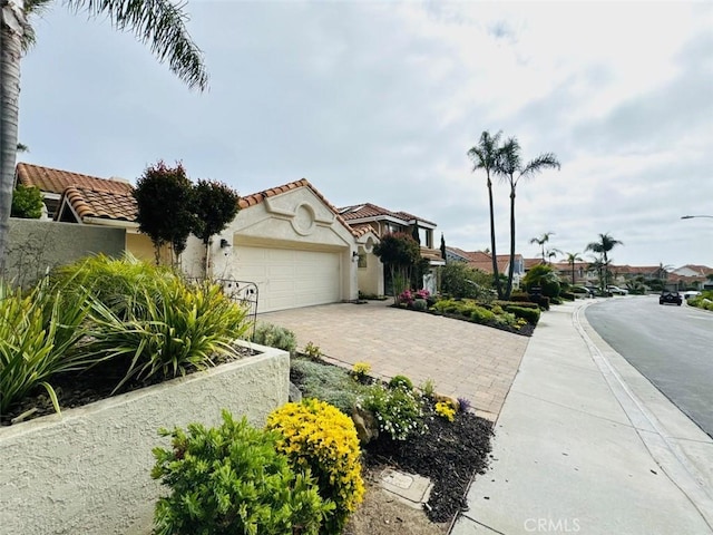 83 Palm Beach Ct, Dana Point, CA 92629 - view of front of home featuring an attached garage, stucco siding, decorative driveway, and a tiled roof