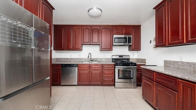 4440 Daniel Dr, Riverside, CA 92503 - kitchen with stainless steel appliances, dark brown cabinets, light tile patterned flooring, and light stone counters