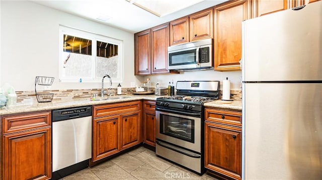 3069 Brea Blvd Unit 10, Fullerton, CA 92835 - kitchen with appliances with stainless steel finishes, brown cabinetry, and light tile patterned floors
