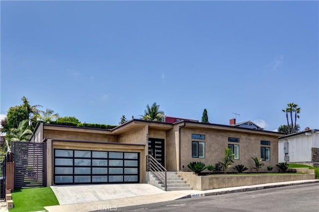 4557 Don Timoteo Dr, Los Angeles, CA 90008 - view of front facade featuring stucco siding, a garage, and driveway