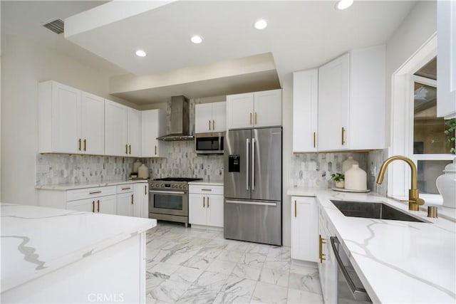 4557 Don Timoteo Dr, Los Angeles, CA 90008 - kitchen with appliances with stainless steel finishes, wall chimney exhaust hood, light stone counters, white cabinetry, and recessed lighting