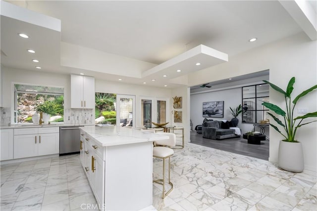 4557 Don Timoteo Dr, Los Angeles, CA 90008 - kitchen with dishwasher, light stone counters, white cabinetry, recessed lighting, and a kitchen bar