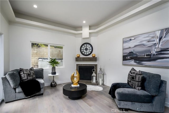 4557 Don Timoteo Dr, Los Angeles, CA 90008 - living area featuring a fireplace with raised hearth, a tray ceiling, wood finished floors, and recessed lighting