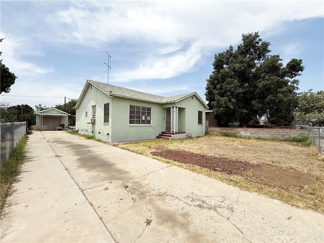 3864 Myers St, Riverside, CA 92503 - view of front of property featuring driveway, stucco siding, a garage, and an outbuilding