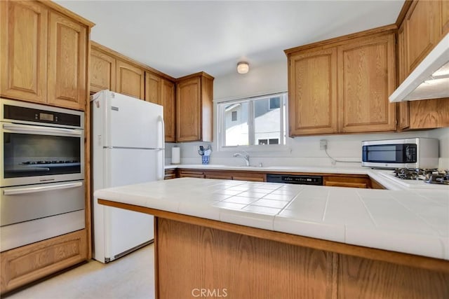 9452 El Valle Ave, Fountain Valley, CA 92708 - kitchen with appliances with stainless steel finishes, under cabinet range hood, tile counters, a warming drawer, and a peninsula