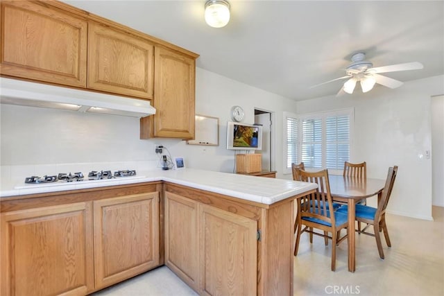 9452 El Valle Ave, Fountain Valley, CA 92708 - kitchen featuring a peninsula, white gas stovetop, under cabinet range hood, ceiling fan, and light brown cabinets