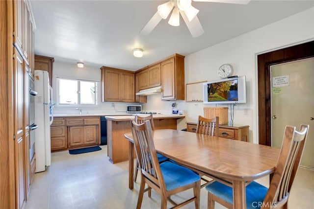 9452 El Valle Ave, Fountain Valley, CA 92708 - kitchen featuring under cabinet range hood, light countertops, a peninsula, stainless steel microwave, and a ceiling fan