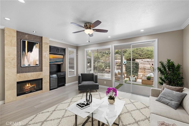 9 Cranwell, Aliso Viejo, CA 92656 - living area featuring light wood-style flooring, ornamental molding, ceiling fan, a fireplace, and recessed lighting