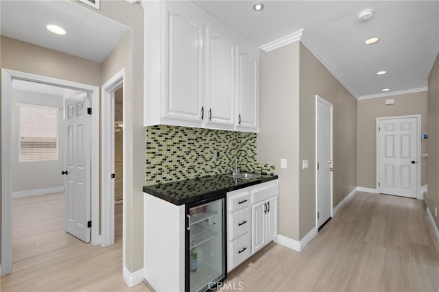 9 Cranwell, Aliso Viejo, CA 92656 - bar area featuring wine cooler, light wood-type flooring, crown molding, backsplash, and recessed lighting