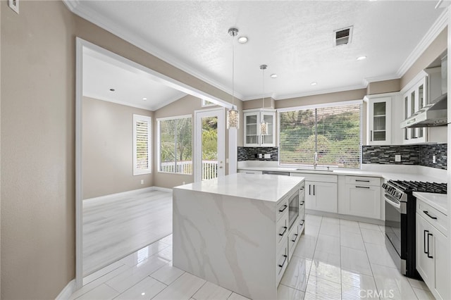9 Cranwell, Aliso Viejo, CA 92656 - kitchen with gas range, healthy amount of natural light, tasteful backsplash, a kitchen island, and crown molding