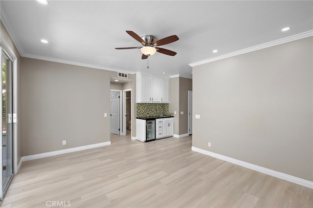9 Cranwell, Aliso Viejo, CA 92656 - unfurnished living room featuring wine cooler, ceiling fan, light wood-style floors, crown molding, and recessed lighting