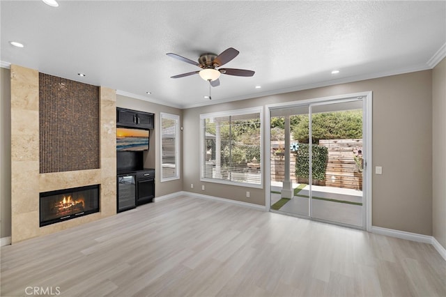 9 Cranwell, Aliso Viejo, CA 92656 - unfurnished living room with ornamental molding, light wood finished floors, a ceiling fan, a tiled fireplace, and recessed lighting