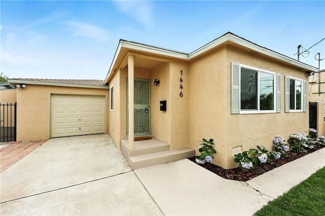 1446 Ravenna Ave, Wilmington, CA 90744 - view of front facade with stucco siding, an attached garage, and driveway