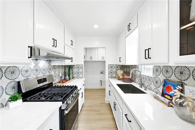 1446 Ravenna Ave, Wilmington, CA 90744 - kitchen featuring stainless steel range with gas stovetop, under cabinet range hood, light countertops, light wood finished floors, and white cabinets