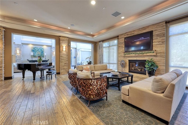 6792 Vanderbilt St, Chino, CA 91710 - living room featuring hardwood / wood-style flooring, a tray ceiling, a stone fireplace, and recessed lighting